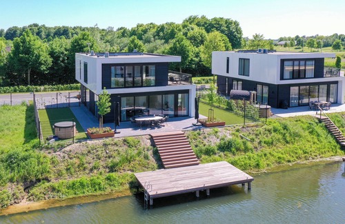 Biddinghuizen House | Luxury 10-person villa on the water with hot tub, private jetty, spacious terrace and 4 bedrooms. Located at Villa Resort Harderwold, near Harderwijk and the Veluwemeer!